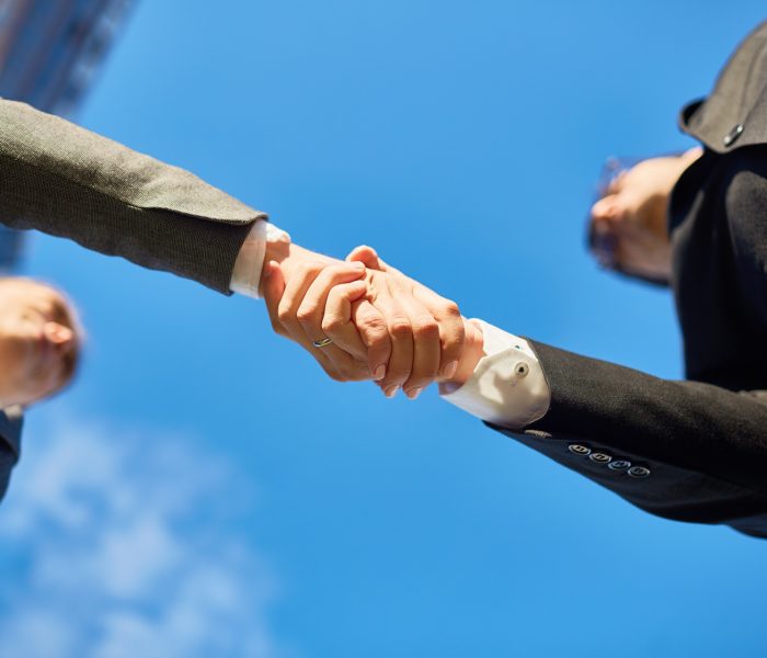Hands of partners Handshake of partners and blue sky above